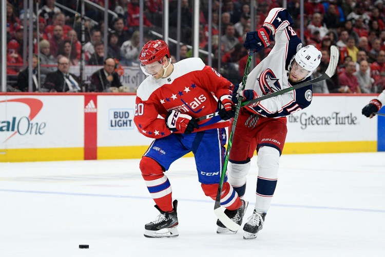 Washington's Lars Eller (20) and  Pierre-Luc Dubois of Columbus vie for the puck during Friday's game in Washington. 