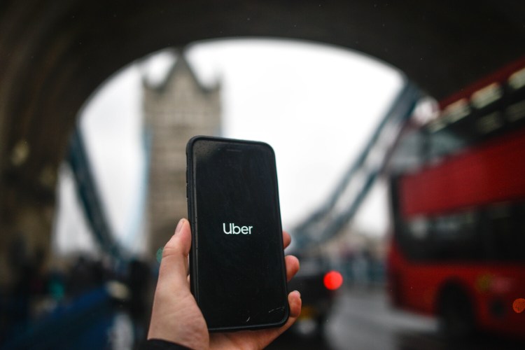 The Uber logo is displayed on a phone in front of Tower Bridge on November 25 in London, England.