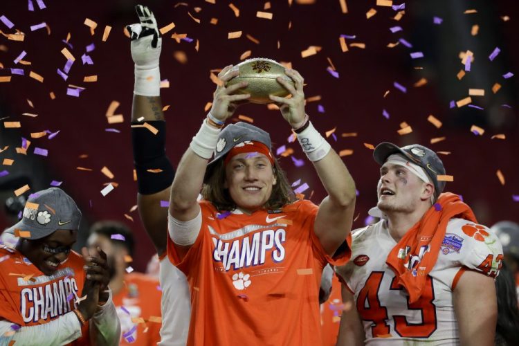 Clemson quarterback Trevor Lawrence holds up the trophy after Clemson's 29-23 win over Ohio State in the Fiesta Bowl on Saturday in Glendale, Ariz. The Tigers are playing in their fourth title game in five years and haven't lost in nearly two years.