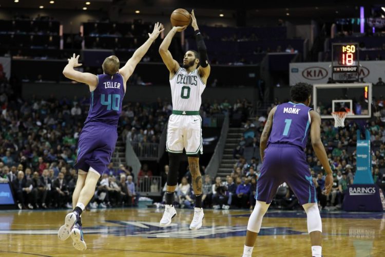 Boston's Jayson Tatum takes a 3-pointer with Charlotte's Cody Zeller defending. Tatum scored 24 points and Boston earned a 109-92 win Tuesday in Charlotte, North Carolina.