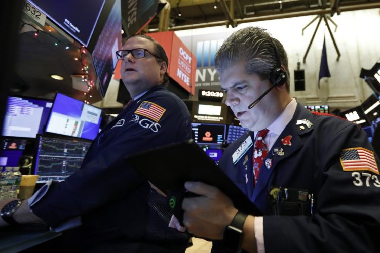 Specialist Gregg Maloney, left, and trader John Panin work on the floor of the New York Stock Exchange this month. The Nasdaq composite climbed above 9,000 points for the first time on Thursday.