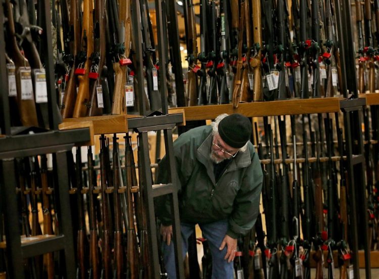 A man looks at the shotgun section of Cabela's while shopping on Black Friday in Hazelwood, Mo. The number of background checks conducted by federal authorities is on pace to break a record by the end of this year. 
