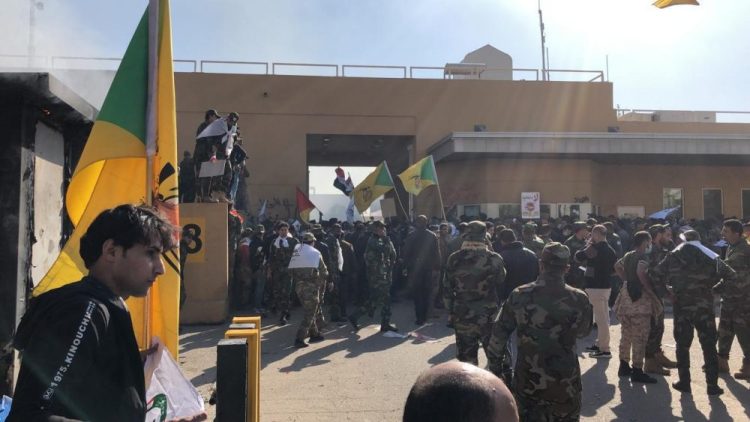 Dozens of Iraqi Shiite militia supporters gather outside the U.S. embassy compound in Baghdad, Iraq, on Tuesday. An angry mob smashed a door and stormed into the compound Tuesday after deadly U.S. airstrikes Sunday against the Kataeb Hezbollah militia in Iraq and Syria. 