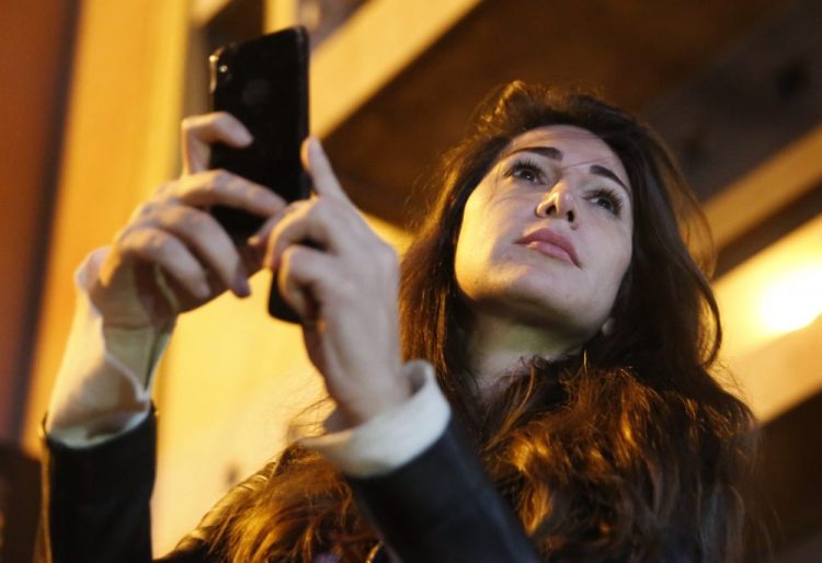 Lebanese anchorwoman Dima Sadek uses her cellphone to film an anti-government protest, in Beirut, Lebanon, on Dec. 4. Sadek, who last month resigned at LBC TV, blamed Hezbollah supporters for stealing her phone while she was filming protests, and said the harassment was followed by insulting and threatening phone calls to her mother, who suffered a stroke as a result of the stress.