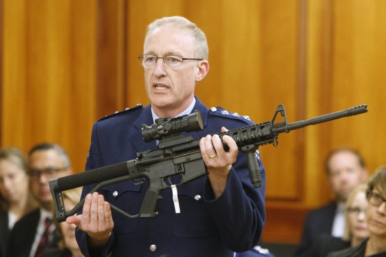 Acting police superintendent Mike McIlraith shows New Zealand lawmakers an AR-15 style rifle similar to one of the weapons a gunman used to slaughter 51 worshippers at two Christchurch mosques, in Wellington this year. 
