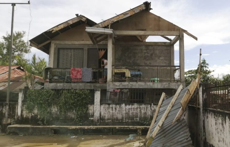 A resident checks his home damaged by Typhoon Phanfone in Ormoc city, central Philippines, on Thursday.