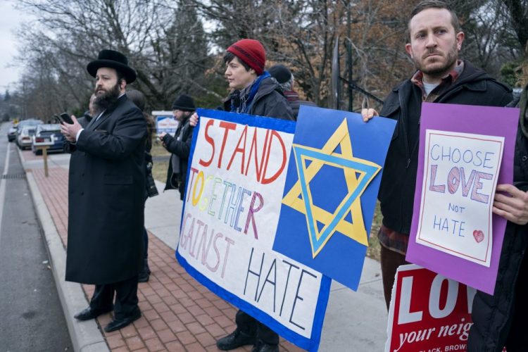 Neighbors gather to show their support of the community near a rabbi's residence in Monsey, N.Y., Sunday, Dec. 29, 2019, following a stabbing Saturday night during a Hanukkah celebration. (AP Photo/Craig Ruttle)