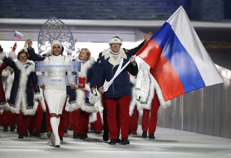 Alexander Zubkov of Russia carries the national flag as he leads the team during the opening ceremony of the 2014 Winter Olympics in Sochi, Russia. The Russian flag and anthem have been banned from international competition for four years by an anti-doping agency.