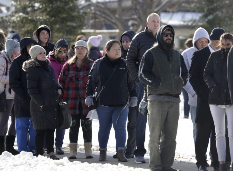 Parents wait in line to be reunited with students at the Tipler Middle School reunification center on Tuesday in Oshkosh, Wis. Earlier, police responded to an officer involved shooting at Oshkosh West High School after an armed student confronted a school resource officer. 