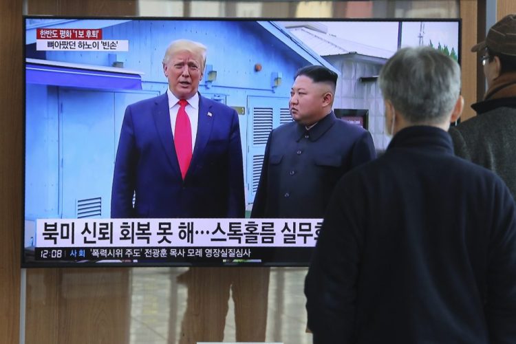 People watch a TV screen showing a file image of North Korean leader Kim Jong Un and President Trump during a news program at the Seoul Railway Station in Seoul, South Korea, on Tuesday. Kim called for active "diplomatic and military countermeasures" to preserve the country's security.