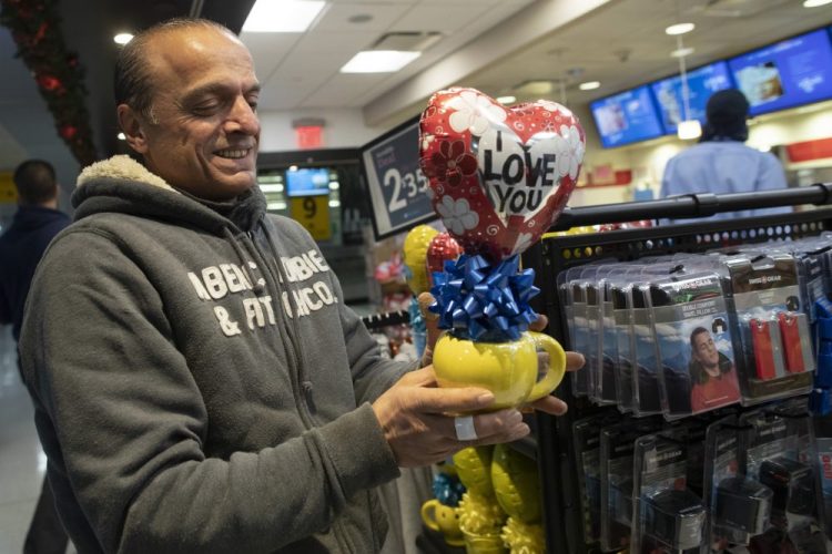 Mohammed Hafar buys a gift for his daughter Jana Hafar while waiting for her flight at JFK airport in New York on Dec. 3. Jana had been forced by President Trump's travel ban to stay behind in Syria for months while her father, his wife and son Karim started rebuilding their lives in Bloomfield, N.J.