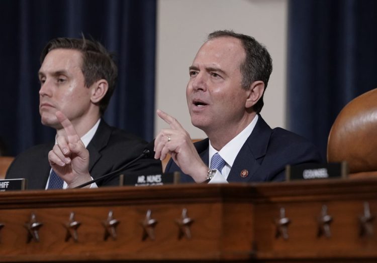 House Intelligence Committee Chairman Adam Schiff, D-Calif., with committee staffer Daniel Noble at left, makes impassioned remarks at the conclusion of a week of public impeachment hearings on President Trump's efforts to tie U.S. aid for Ukraine to investigations of his political opponents, on Capitol Hill in Washington last month. The committee released its report on Tuesday.