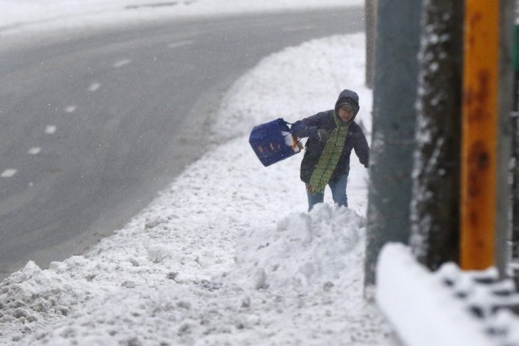 A pedestrian walks through deep snow Monday after an overnight snowfall in Marlborough, Mass. Associated Press/Bill Sikes