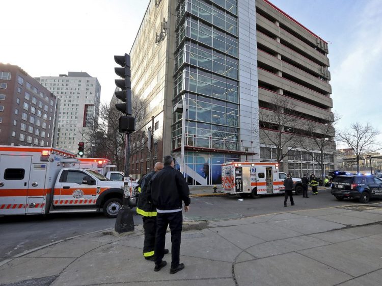 Emergency personnel at the Renaissance Park Garage in Boston, where a mother and two children were found dead on a sidewalk on Christmas Day.