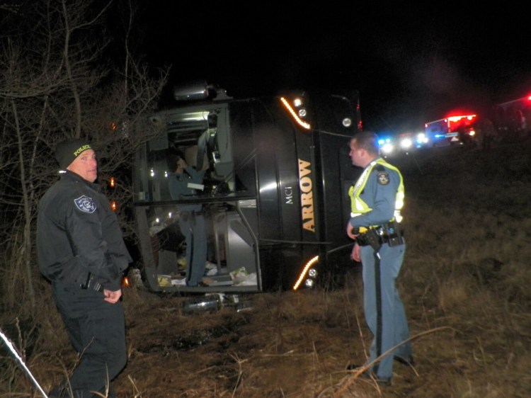 Maine State Police troopers respond to the scene of a bus crash on I-95 in Burnham late Tuesday night.