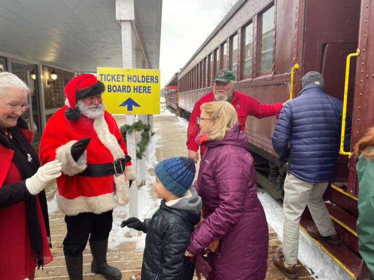 Santa and Mrs. Clause wave goodbye Sunday to patrons after the train ride in Unity.