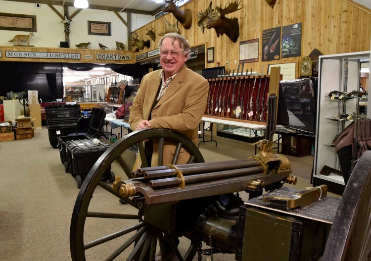 Auctioneer Jim Julia on Jan. 11, 2018, leans on an 1870s gatling gun that will be auctioned at his James D. Julia Auction Inc. business in Fairfield. The company Julia sold his auction house to has sued him for breach of contract.
