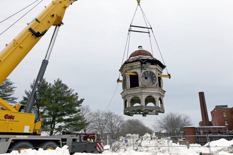 The 140-year-old Biddeford Mills Clock Tower is relocated to a neighboring property by workers from the Cote Corporation on Friday. 