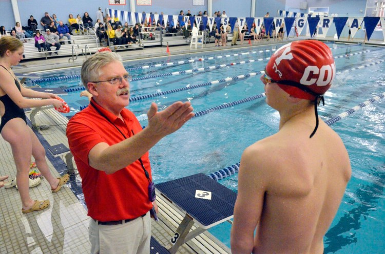 Cony coach Bob Johnston talks to Jack Begin during a meet last season at the Kennebec Valley YMCA in Augusta. 