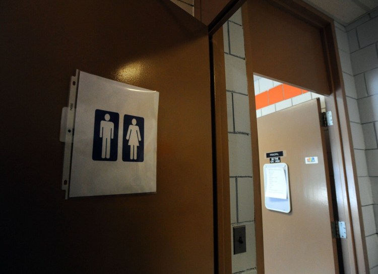 Signage for a gender-neutral bathroom is seen Wednesday on a door in the main office of Skowhegan Area High School. 