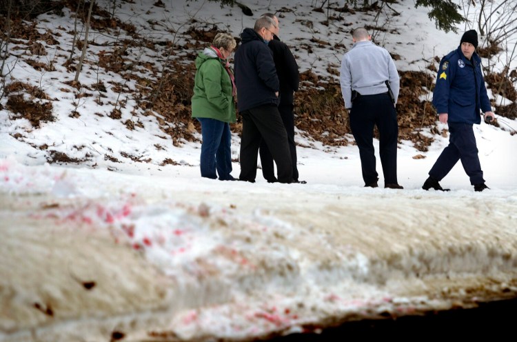 Maine State Police detectives escort  Assistant Attorney General Meg Elam along a blood trail from a shooting and stabbing that occurred in the early hours of Saturday in Gardiner.