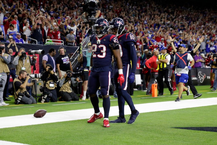 Texans running back Carlos Hyde, 23,  celebrates with DeAndre Hopkins after scoring a touchdown against the Buffalo Bills on Saturday in Houston. The Texans beat the Bills 22-19 in overtime in an AFC wild-card game.