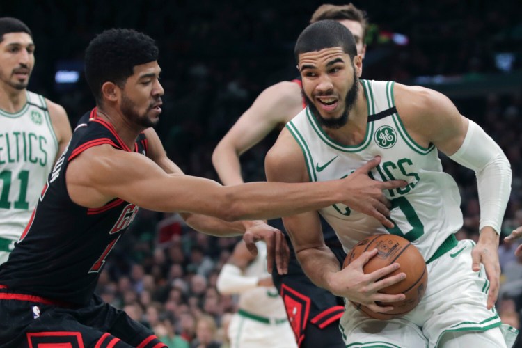 Chicago forward Chandler Hutchison , left, tries to steal the ball from Boston forward Jayson Tatum during the Celtics' 113-101 win Monday in Boston. Tatum finished with 21 points. 