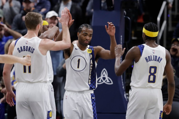 Indiana's T.J. Warren, center, is congratulated by Domantas Sabonis, left, and Justin Holiday for blocking the shot of Philadelphia's Tobias Harris in the second half of the Pacers 101-95 win Monday in Indianapolis.