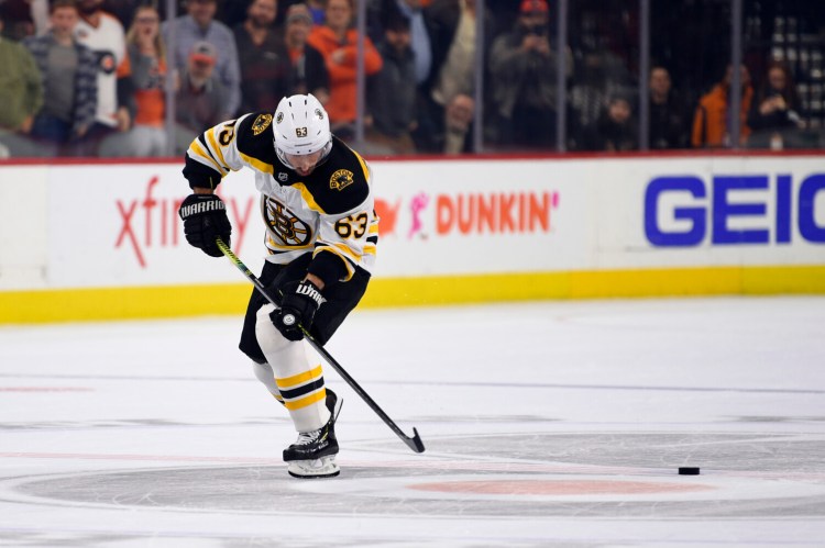 Boston's Brad Marchand misses the puck on his way to the goal on a shootout attempt on Monday against Philadelphia. Marchand didn't score and the Bruins lost 6-5.