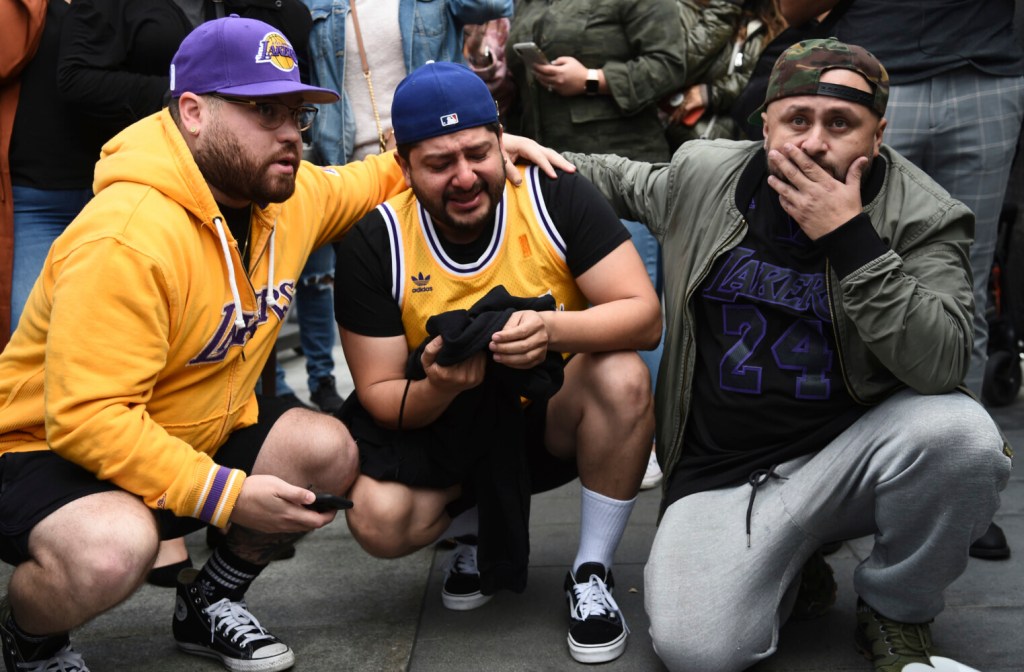 Los Angeles Lakers fans Alex Fultz, from left, Eddy Rivas and Rene Alfaro react to the death of former NBA player Kobe Bryant outside of the Staples Center prior to the 62nd annual Grammy Awards on Sunday, Jan. 26, 2020, in Los Angeles. Bryant died Sunday in a helicopter crash near Calabasas, Calif. He was 41. (AP Photo/Chris Pizzello)