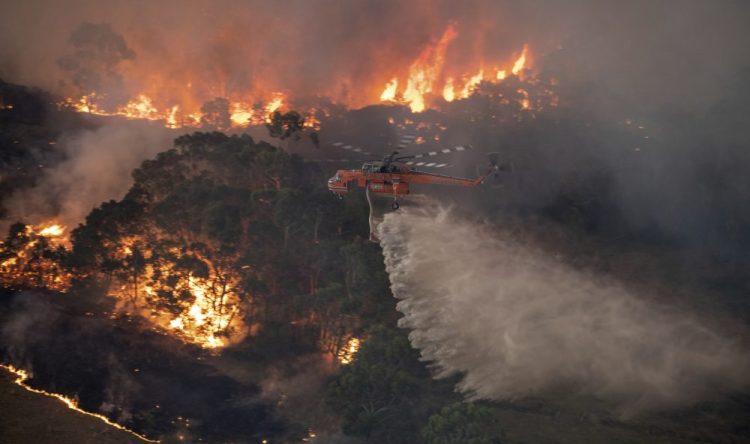 In this Monday, Dec. 30, 2019 photo provided by State Government of Victoria, a helicopter tackles a wildfire in East Gippsland, Victoria state, Australia. 