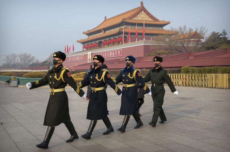 Security officials wear face masks as they march in formation near Tiananmen Gate adjacent to Tiananmen Square in Beijing, Monday, Jan. 27, 2020. China on Monday expanded sweeping efforts to contain a viral disease by postponing the end of this week's Lunar New Year holiday to keep the public at home and avoid spreading infection as the death toll rose to 80. (AP Photo/Mark Schiefelbein)
