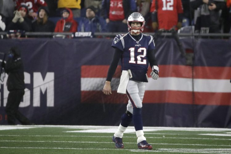 New Patriots quarterback Tom Brady walks to the sideline after throwing an interception late in the second half of an NFL wild-card playoff game against the Tennessee Titans.