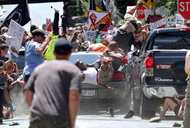 People fly into the air as a vehicle drove into a group of protesters demonstrating against a white nationalist rally in Charlottesville, Va., Saturday, Aug. 12, 2017. 