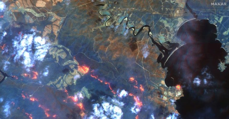 This satellite photo  shows wildfires spreading in the area south of Eden and Twofold Bay, shown in black, in New South Wales state of Australia, on Sunday. 
