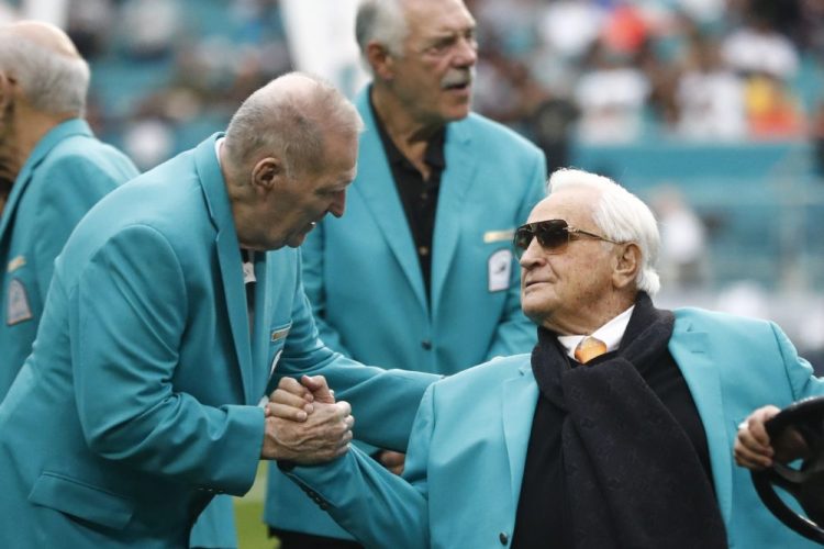 Former Miami Dolphins head coach Don Shula is greeted on the field by former players. 
