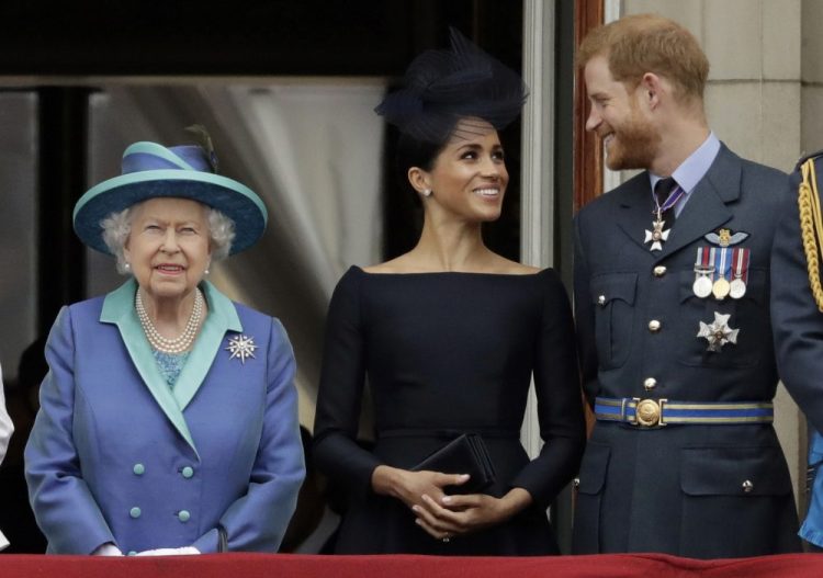 Britain's Queen Elizabeth II, and Meghan the Duchess of Sussex and Prince Harry watch a flypast of Royal Air Force aircraft pass over Buckingham Palace in London on July 10, 2018. Royal officials said the queen had summoned her grandsons and their father to Sandringham Estate for a meeting on Monday. 