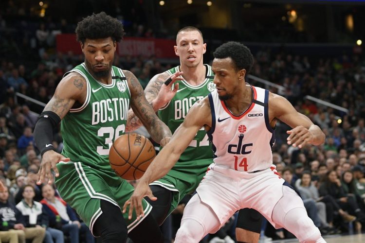Celtics guard Marcus Smart, left, forward Daniel Theis, center,  and  Wizards guard Ish Smith  battle for the ball during Washington's 99-94 win Monday in Washington. 