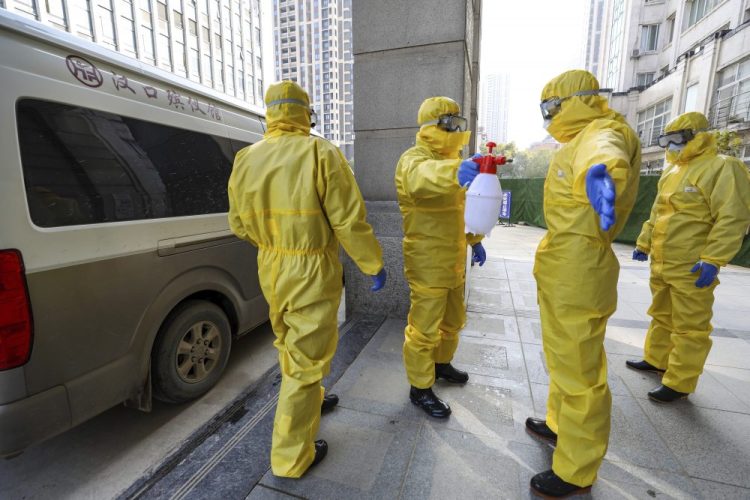 Funeral workers disinfect themselves after handling a virus victim in Wuhan in central China's Hubei Province on Thursday.