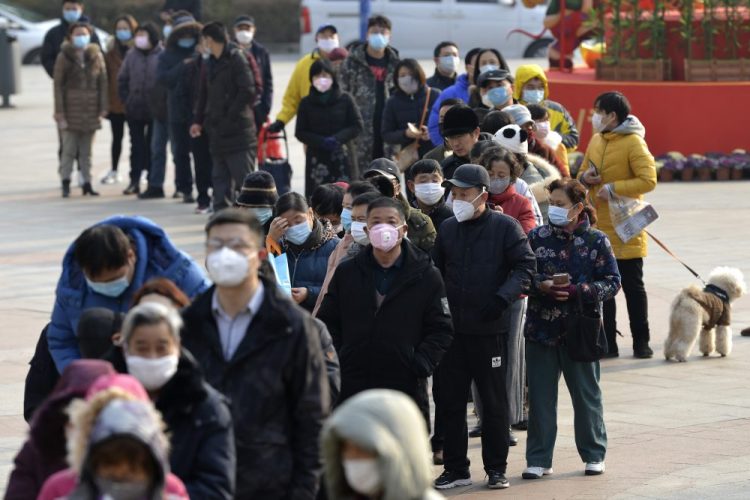 People line up to buy face masks at a drug store Wednesday in Nanjing in eastern China's Jiangsu Province. Countries began evacuating their citizens Wednesday from the Chinese city hardest-hit by an outbreak of a new virus that infected more than 6,000 on the mainland and abroad. 