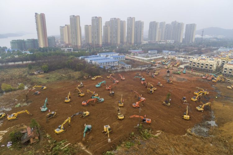 Heavy equipment works at a construction site for a field hospital in Wuhan in central China's Hubei Province, where the coronavirus outbreak origniated. Chinatopix via AP
