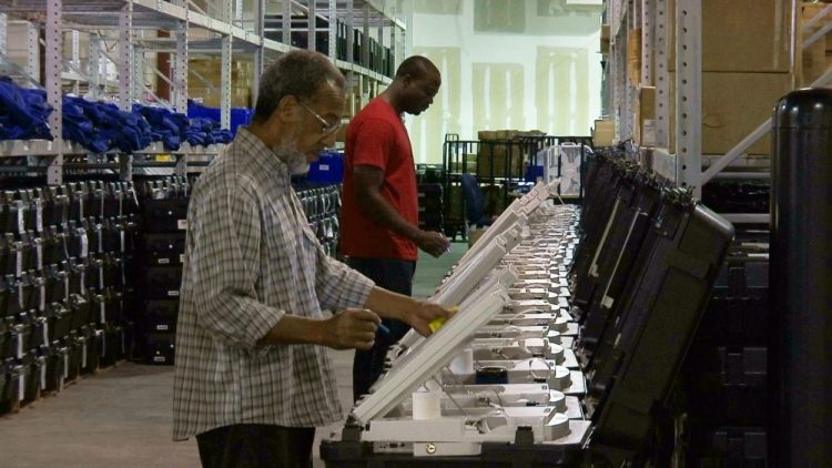 Employees of the Fulton County Election Preparation Center in Atlanta test electronic voting machines in 2016. A computer security expert says he found that an election server central to a legal battle over the integrity of Georgia elections showed signs of tampering. 