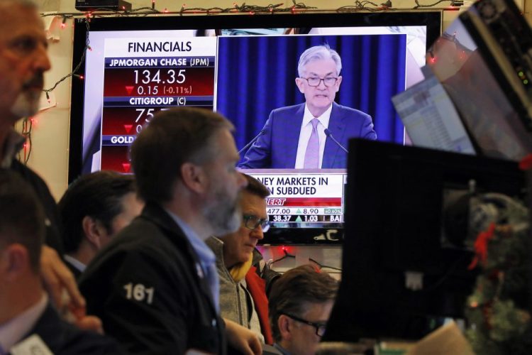 A television screen on the floor of the New York Stock Exchange shows Federal Reserve Board Chair Jerome Powell's Washington news conference Dec. 11. The Federal Reserve approved a proposal Thursday to loosen a financial-crisis era rule that prevents banks from investing in venture capital funds.