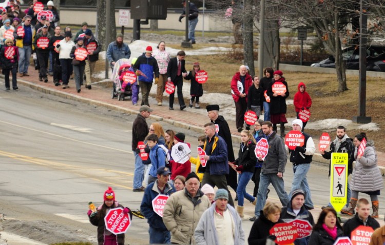 Participants in the 2019 Hands Around the Capitol event march from St. Michael School in Augusta to the State House, where they joined hands in silent protest while the capitol bell was rung 46 times, once for each year that had passed since the Roe v. Wade ruling which legalized abortion.