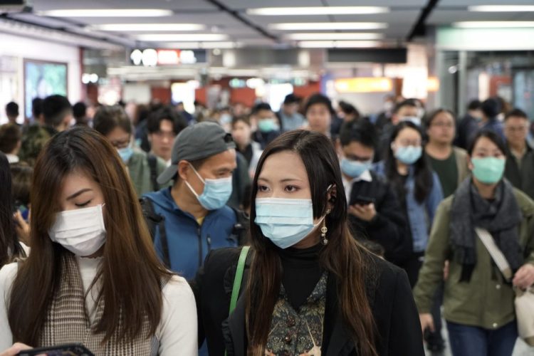 Passengers wear masks Wednesday to prevent an outbreak of a new coronavirus in a subway station in Hong Kong.