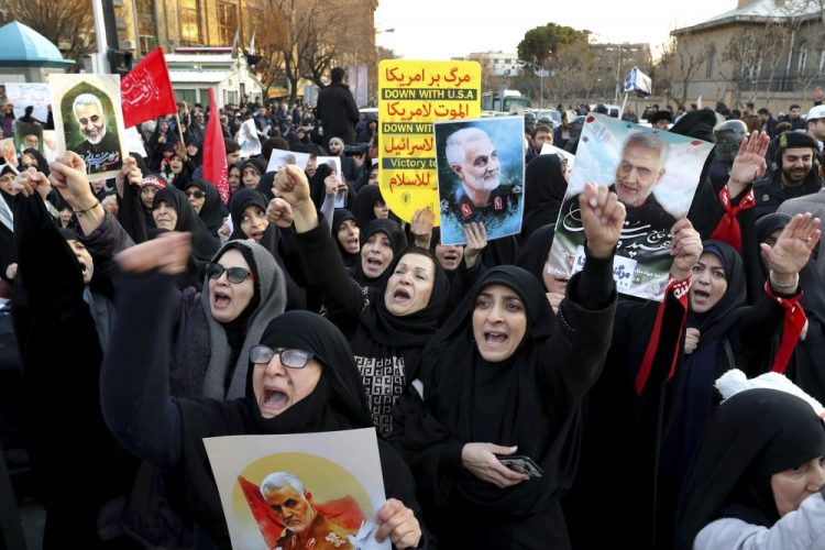 Protesters chant slogans while holding up posters of Gen. Qassem Soleimani during a demonstration Sunday in front of the British Embassy in Tehran, Iran.