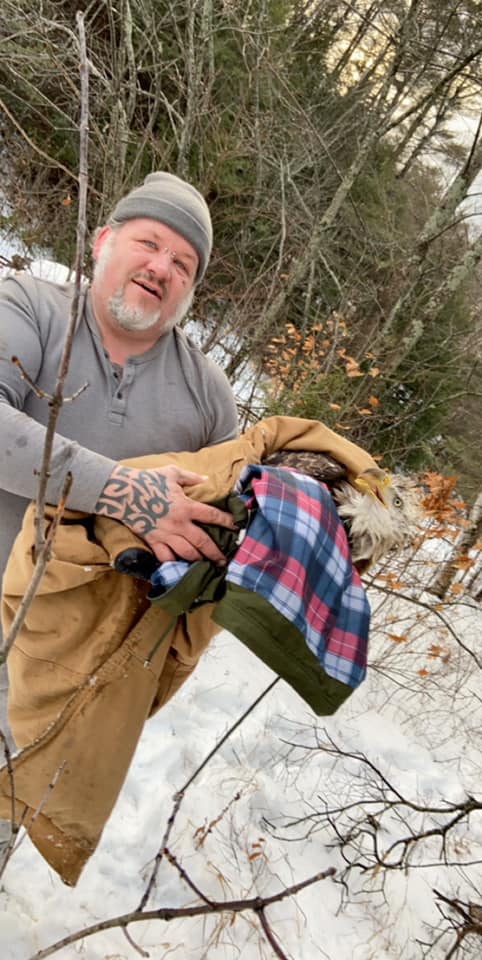 Jason Dolloff holds an injured bald eagle he and his daughter, Carrigan Robinson, rescued Sunday from the Androscoggin River in Peru.
