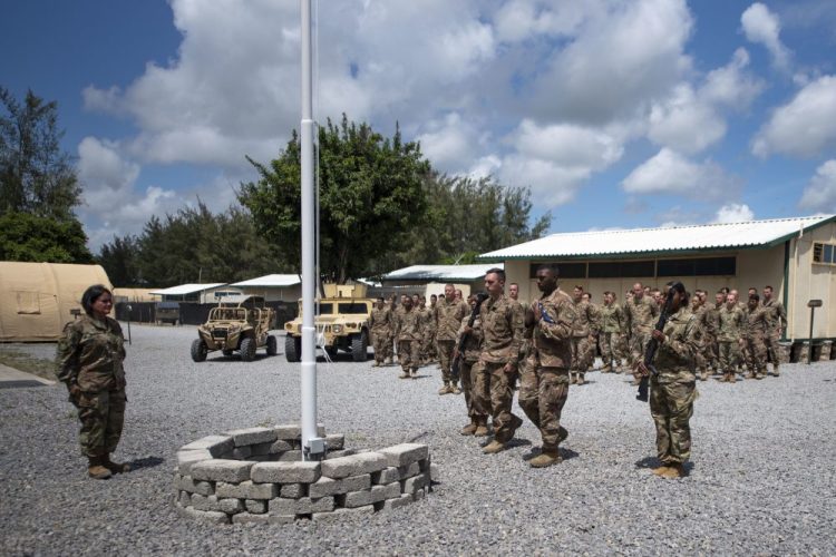 Airmen from the 475th Expeditionary Air Base Squadron conduct a flag-raising ceremony, signifying the change from tactical to enduring operations, at Camp Simba, Manda Bay, Kenya. The al-Shabab extremist group said Sunday that it has attacked the Camp Simba military base used by U.S. and Kenyan troops in coastal Kenya, while Kenya's military says the attempted pre-dawn breach was repulsed and at least four attackers were killed.
