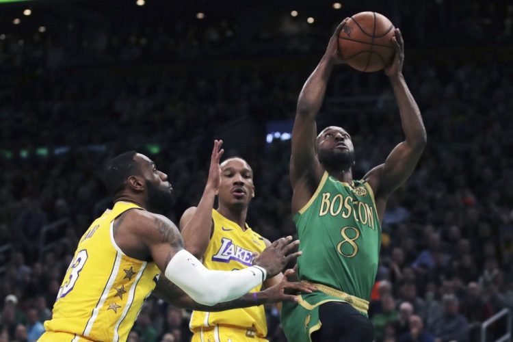 Celtics guard Kemba Walker drives to the basket past Lakers guard Avery Bradley, center, and forward LeBron James (23) during the first half of the Celtics' 139-107 win Monday in Boston.