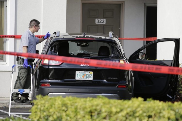 A forensic technician works on the vehicle authorities say breached security at President Trump's Mar-a-Lago resort in Palm Beach on Friday. 